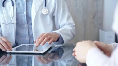 Klinikteki tablet bilgisayarla doktor ve hasta sohbeti. İlaç ve Sağlık Hizmetleri.