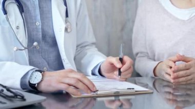 Not almak için bir pano kullanan bir doktora danışıyorum. Klinikteki tıp bürosu. Tıp konsepti.