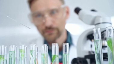 Güvenlik gözlüklü bir araştırmacı laboratuvar borularıyla laboratuvar ekipmanlarına yakın çekim yapıyor. Bilim ve tıp.