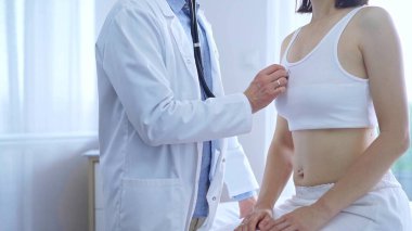 Doktor ve hasta. Doktor, klinikteki kadın ciğerlerini incelemek için steteskop kullanıyor. İlaç ve sağlık hizmetleri.