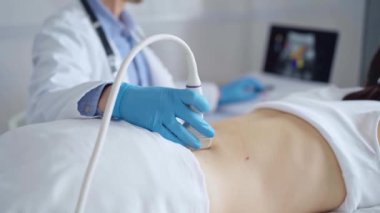 Mavi koruyucu eldiven giyen doktor bir hastanın sırtında ultrason cihazı kullanıyor, kadın. Tıp ve Bilim