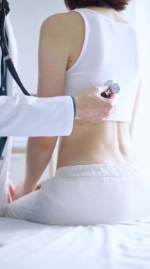 Doktor ve hasta. Doktor steteskop kullanarak kadın ciğerlerini inceliyor. İlaç ve sağlık hizmetleri.