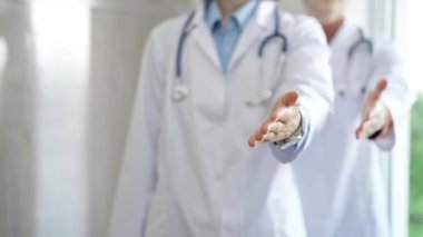 Bir grup doktor hastanede dururken yardım eli uzatıyorlar. Takım çalışması ve tıpta başarı.