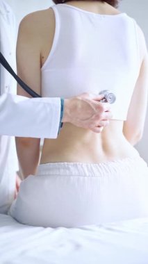 Doktor ve hasta. Doktor steteskop kullanarak kadın ciğerlerini inceliyor. İlaç ve sağlık hizmetleri.