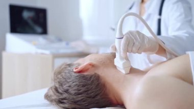 Beyaz koruyucu eldivenli doktor kadın klinik prosedür dolabında yatan erkek göğüs röntgeni çekiyor. Kardiyoloji teşhisi ve tıp hizmeti kavramı.