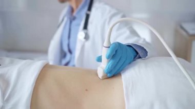 Mavi koruyucu eldiven giyen doktor bir hastanın sırtında ultrason cihazı kullanıyor, kadın. Tıp ve Bilim