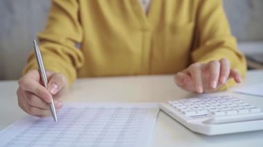 Sarı mavisi olan iş kadını şirket harcamalarını hesaplıyor ve not alıyor. İş hayatında vergiler ve denetim