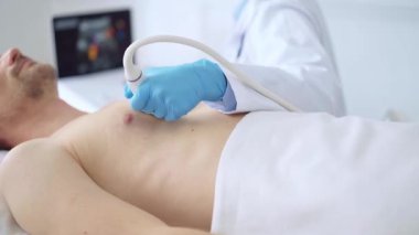 Doktor kadın mavi eldiven giyip erkek hastaya göğüs ultrasonu yapıyor. Tıp hizmeti, kardiyoloji.