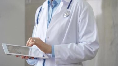 Doktor kadın laboratuvar önlüğü ve steteskop giyiyordu. Hastanede tablet bilgisayar kullanıyordu. Tıp ve bilim konsepti.