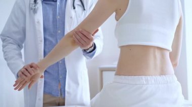 Doktor, bir klinikte tıbbi muayene sırasında hastaların dirseğini muayene eder. Tıp ve ortopedi kavramı..