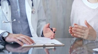 Doktor, elinde kalemle elinde dosya olan bir hastaya danışmanlık yapıyor. Tıbba güven kavramı.