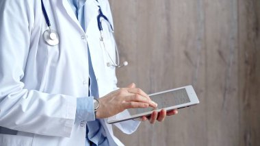 Doctor at work. Unrecognizable medical professional using digital tablet showcasing modern medical technology, close up clipart