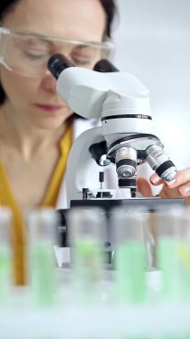 Laboratuvarda mikroskop kullanan kadın bilim adamı. Mikrobiyoloji bilim konsepti.