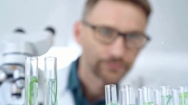 Güvenlik gözlüklü bir araştırmacı laboratuvar borularıyla laboratuvar ekipmanlarına yakın çekim yapıyor. Bilim ve tıp.