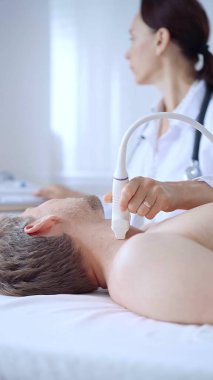 Doktor kadın erkek hastaya boyun ultrasonu yapıyor. Tıp hizmeti kavramı.