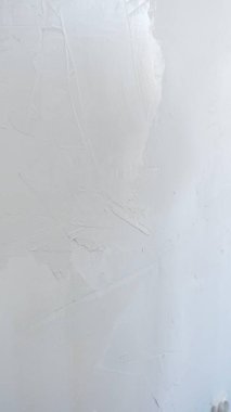 Duvar, son malayı kullanmak için bekliyor. Alçıyı dikkatlice uygulamak, ev yenileme konusunda uzmanlık göstermek için..