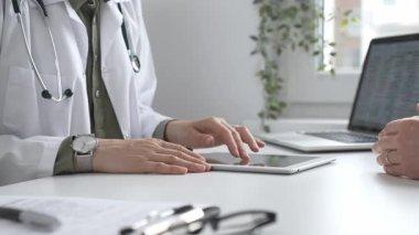 Dijital test sonuçlarını hastayla inceleyen kadın doktor, modern klinik ortamdaki tıbbi bulguları, sağlık teknolojisi etkileşimini tartışıyor. İlaç ve sağlık hizmetleri kavramı