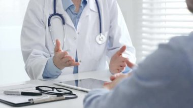 Klinikte muayene sırasında hastaya tıbbi bilgiler veren doktor teşhis ve tedavi seçeneklerini tartışıyor. İlaç ve sağlık hizmetleri kavramı