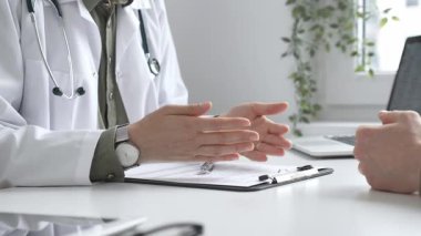 Doktor, tıbbi muayene sırasında hastaya el kol hareketi yaparak teşhisi açıklıyor. İlaç ve sağlık hizmetleri kavramı.