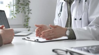 Doktor, tıbbi muayene sırasında hastaya el kol hareketi yaparak teşhisi açıklıyor. İlaç ve sağlık hizmetleri kavramı.