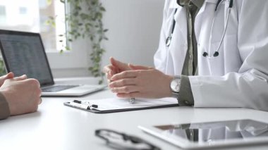 Doktor, tıbbi muayene sırasında hastaya el kol hareketi yaparak teşhisi açıklıyor. İlaç ve sağlık hizmetleri kavramı.