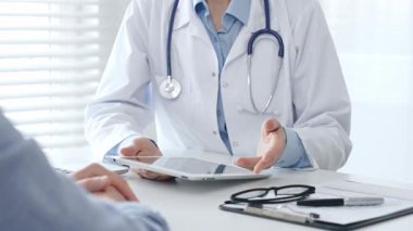 Klinikte muayene sırasında hastaya tıbbi bilgiler veren doktor teşhis ve tedavi seçeneklerini tartışıyor. İlaç ve sağlık hizmetleri kavramı