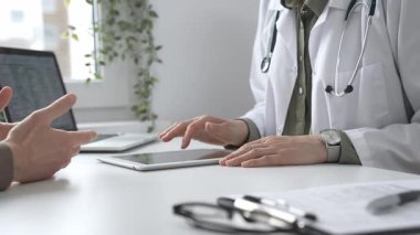 Dijital test sonuçlarını hastayla inceleyen kadın doktor, modern klinik ortamdaki tıbbi bulguları, sağlık teknolojisi etkileşimini tartışıyor. İlaç ve sağlık hizmetleri kavramı