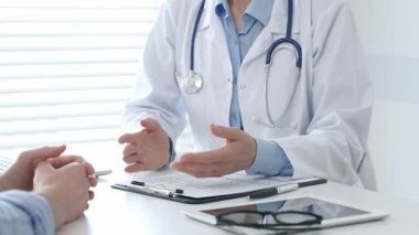 Kadın hekim hastayla tıbbi sonuçları tartışıyor, modern klinik ortamında sağlık bilgileri veriyor, profesyonel tıbbi danışmanlık yapıyor. İlaç ve sağlık hizmetleri kavramı