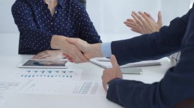 Business people shaking hands, colleagues clapping after sealing significant partnership, expressing professional success and collaborative achievement. Handshake at meeting.