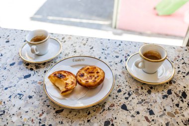 Porto, Portekiz-17Nisan 2023: Pastel de nata Pastel de Belm adlı tipik ve lezzetli hamur işi, Portekiz yapımı tart kremalı turta..