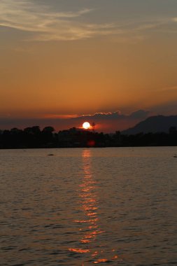 Tepede ve gölde akşam üstü gün batımı. Kaptai Gölü, Bangladeş 'te akşam batımı.