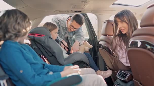 Счастливая Милая Молодая Семья Готовится Автомобильной Поездке Пристегивая Ремни Безопасности — стоковое видео
