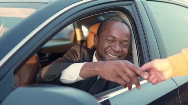 幸せな成功豊かなアフリカ系アメリカ人ビジネスマンのサイドビューの肖像車のキーを取得スーツで 魅力的な陽気な楽しいですアフリカの男性座っています最近買った車 — ストック動画