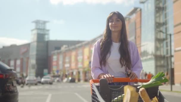 Ein Junges Mädchen Hat Lebensmittel Gekauft Und Trägt Sie Einkaufswagen — Stockvideo