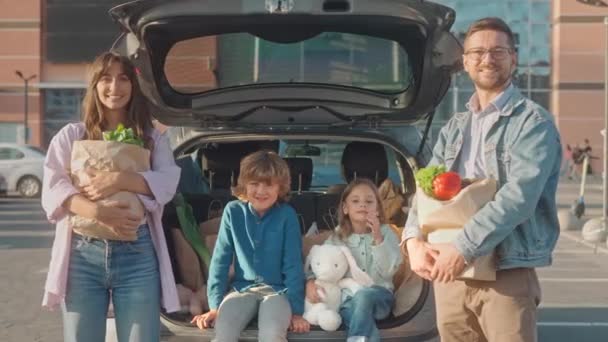 Портрет Щасливої Сім Чотирьох Діти Сидять Багажнику Посміхаються Батьки Тримають — стокове відео
