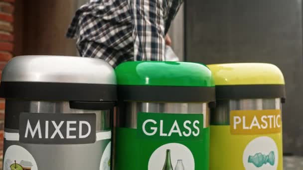 漂亮的瓶子玻璃垃圾箱垃圾箱 人类把五颜六色的玻璃瓶塞入回收站 人类废物回收可以 男士们在整理垃圾箱 环境护理 — 图库视频影像