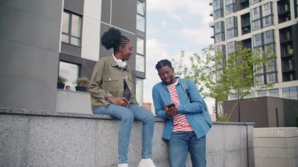 그녀의 친구가 자신의 전화기를 사용하는 콘크리트에 아프리카계 미국인 거리에서 만나는 — 비디오