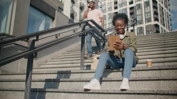 Nettes Afroamerikanisches Mädchen Sitzt Auf Einer Treppe Und Benutzt Ein — Stockvideo