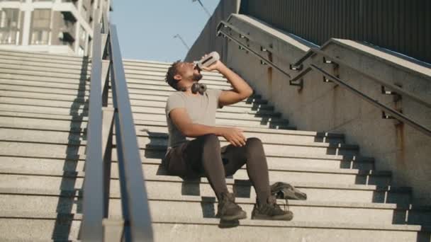 Caméra Glissant Devant Homme Afro Américain Assis Sur Escalier Béton — Video