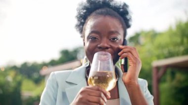 Dışarıda kutlama yapan şarap kadehinden alkol içen genç ve güzel bir kız. Ev bahçesinde akıllı telefondan konuşan oldukça çekici bir Afrikalı Amerikalı kadın. Cep telefonu ve modern yaşam tarzı kavramı.