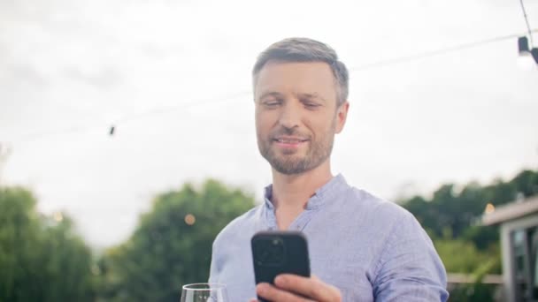 성숙한 매력적인 부유한 전화로 메시지 만드는 파티에서 휴가를 포도주 유리에서 — 비디오