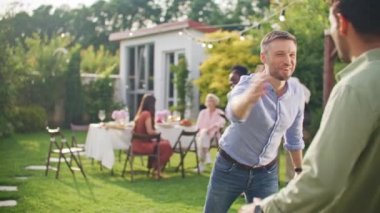 Sürpriz iki gülen arkadaş birbirlerini selamlıyor, el sıkışıyor ve barbekü partisinde tanıştıktan sonra sarılıyorlar. Erkek arkadaşlığı, eğlence ve kutlama kavramı açık havada, temiz havada..