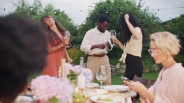Kutlama. Genç ve pozitif insanlar mükemmel bir yaz öğleden sonrasında eğleniyorlar. Çeşitli çok kültürlü arkadaşlar açık hava bahçe partisinde birlikte dans ediyorlar. Arkadaşlık, boş zaman ve hafta sonları konsepti.