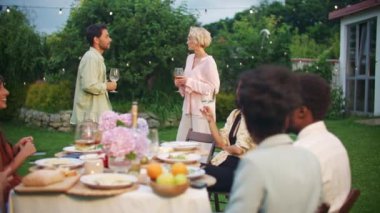 Öğle yemeğinde dışarıda yemekle masada oturan ve meyve suyu ve şarapla kadeh kaldıran mutlu çok ırklı şirket. Neşeli melez gençler akşam yemeği yiyip barbekü partisinde kadeh kaldırıyorlar. Hafta sonu kutlaması.