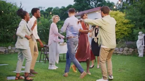 レジャータイム 週末のコンセプト お祝いする 若くてポジティブな人々は 完璧な夏の午後を楽しんでいる アウトドアガーデンパーティーで一緒に踊る多様な多文化の友人 — ストック動画