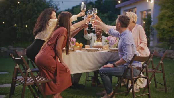 一群不同的人在家里的花园庆祝 在户外的聚会上寒风凛凛 一家人和邻居们聚在一起 在自家门前的院子里一起吃晚餐 喝杯酒 — 图库视频影像
