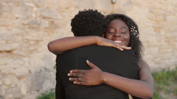 Gelukkige Afro Amerikaanse Echtpaar Trouwkleding Knuffelen Elkaar Voorkant Van Stenen — Stockvideo