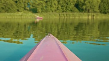Büyük göl ya da göl manzarası. Bulanık arka planda kanoyla yelken açan biri var. Doğada tatil. Güneşli yaz gününde dinlen. Kano sporları hobisi. Çevre. Seyahat kavramı.