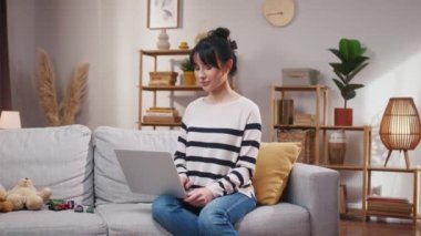 Doğumdan sonra internette çalışan bir kadın. Annem evde çalışıyor ve oğlumla ilgileniyor. Kameraya bakıp gülümseyen bir kadın. Kanepede oturan ve tablet kullanan bir kadın. Kadın neşeyle gülümsüyor..