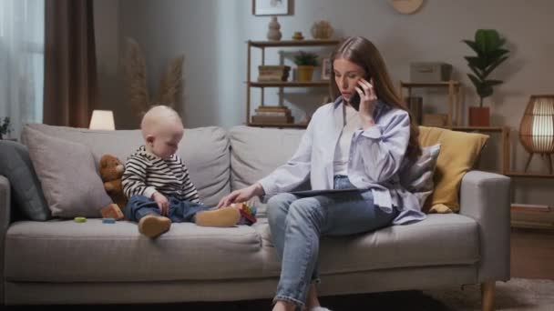 Γυναίκα Μιλάει Τηλεφωνικώς Και Φροντίζει Παιδί Μητέρα Κοιτάει Χαρτί Της — Αρχείο Βίντεο